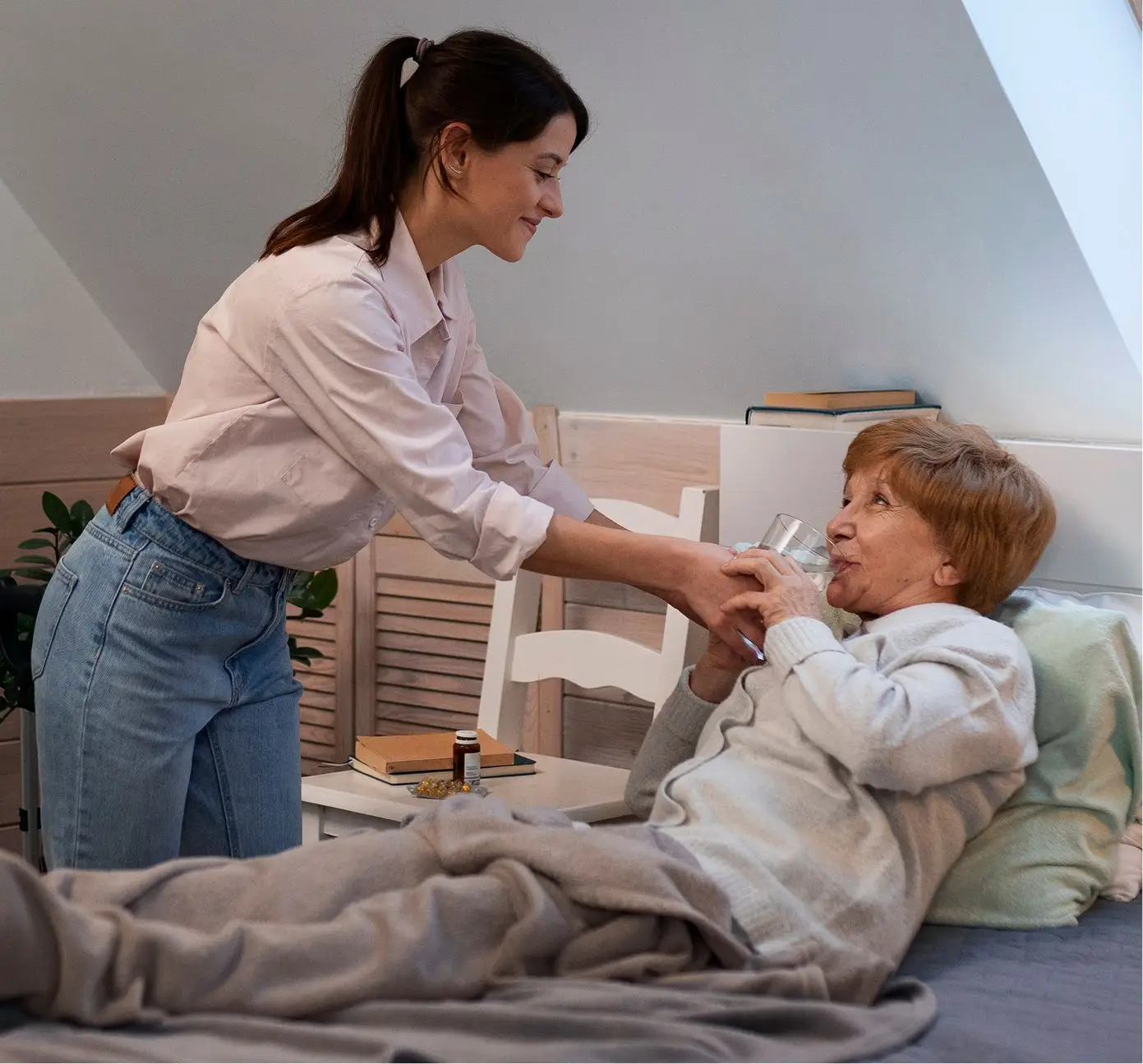 senior woman laying on bed drinking a glass of water